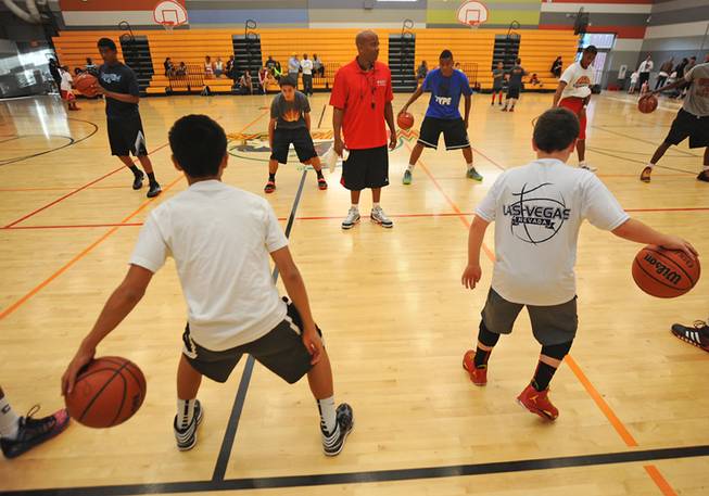 UNLV alumni Dedan Thomas supervises a youth basketball team as they conduct dribbling drills during a practice session in the Western Tech High School gymnasium on Tuesday, April 22, 2014.