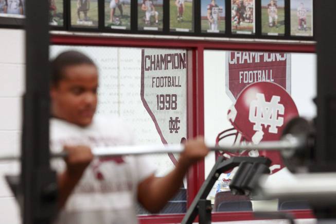Banners from Cimarron Memorial's past football championships hang on the wall as students lift weights in their new weight room Tuesday, April 22, 2014.