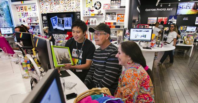 Jerome Tuason assists Roy and Karen Myers of S. Rockwood, Mich., in making Polaroids for their daughter Wednesday, April 23, 2014, at the Polaroid Fotobar. 