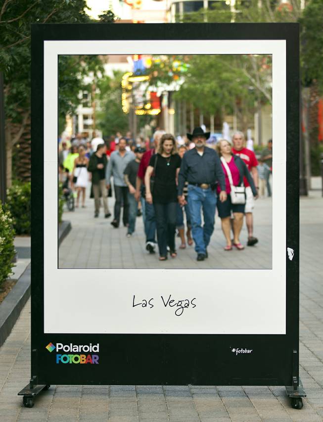 Visitors to the Linq pass by a large frame outside the new Polaroid Fotobar and Polaroid Museum on Wednesday, April 23, 2014, at the Linq.