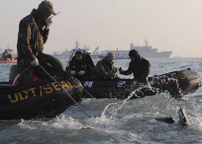 Divers look for people believed to have been trapped in the sunken ferry Sewol in the water off the southern coast near Jindo, south of Seoul, South Korea, Wednesday, April 23, 2014.