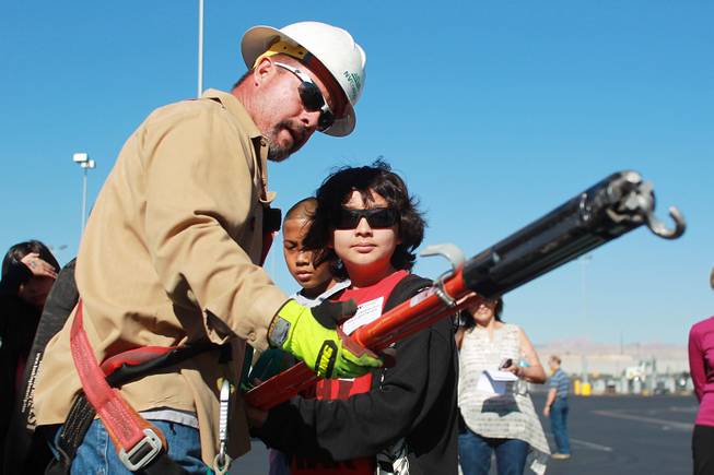 Mark Gutierrez demonstrates the use of equipment to Gregg Parlade during "Take Our Daughters and Sons to Work Day" at NV Energy Thursday, April 24, 2014.
