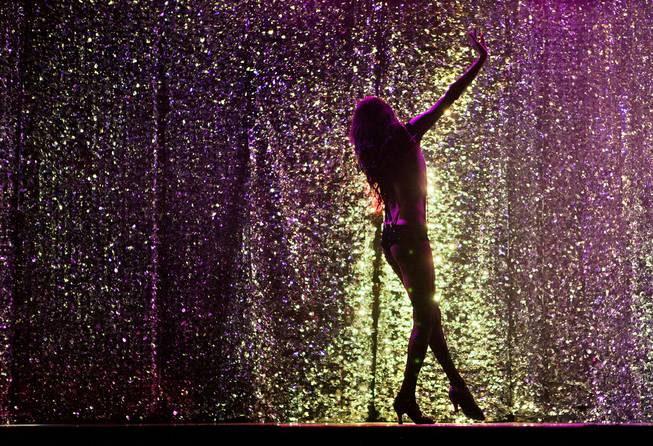 A dancer is bathed in purple light as “X Burlesque” celebrates its 12th anniversary in Las Vegas on Wednesday, April 23, 2014, at the Flamingo.