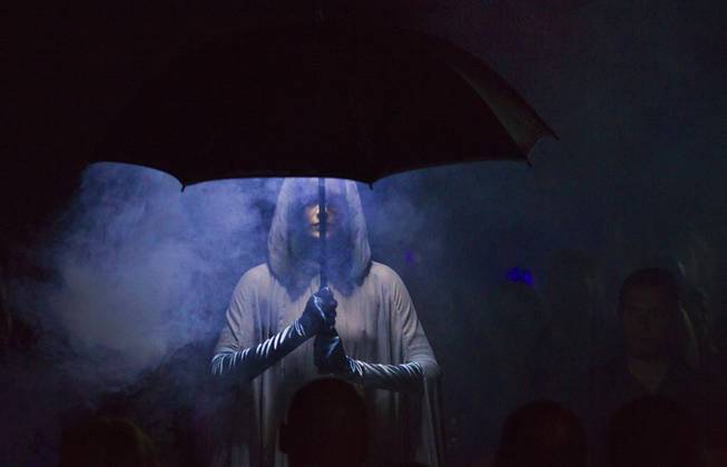 A dancer beneath an umbrella is surrounded by smoke as “X Burlesque” celebrates its 12th anniversary in Las Vegas on Wednesday, April 23, 2014, at the Flamingo.