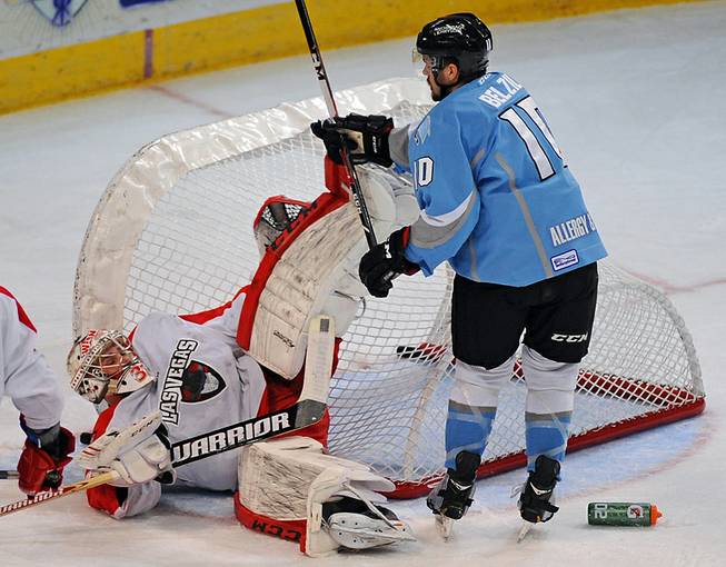 Wranglers goaltender Travis Fullerton is knocked to the ice by Alaskas Aces winger Alex Belzile during the first period of play on Friday night at the Orleans Arena.