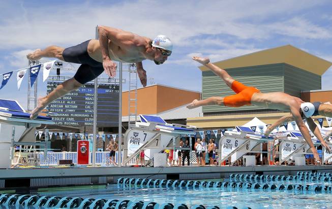 Michael Phelps leaps at the start of a 50-meter freestyle preliminary heat during the Arena Grand Prix swim event, Friday, April 25, 2014, in Mesa, Ariz.