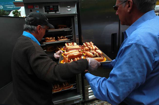 Dogs and buns are loaded into a holding container during qualifying for Nathan's Famous Fourth of July Hot Dog Eating Contest Saturday, April 26, 2014 at New York New York.