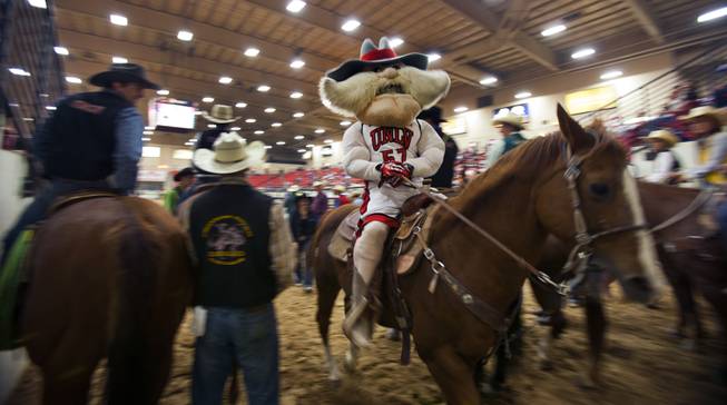 UNLV rodeo competitor Tyler Baeza portrays mascot Hey Reb during the start of the West Coast Regional Finals Rodeo at South Point Arena on Friday, April 25, 2014.