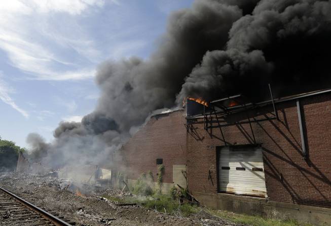 A commercial building burns near downtown Memphis, Tenn., on Saturday, April 26, 2014. Officials say four Memphis firefighters were rescued from the burning building after a wall collapsed on them.