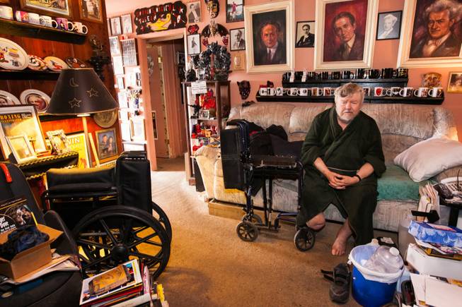Former magician Gary Darwin, who lost his leg to diabetes, sits in his home filled with magician collectibles and memorabilia while volunteers repair the exterior of his home in downtown Las Vegas during an Rebuilding Together Southern Nevada's annual neighborhood rebuilding event in Las Vegas Saturday, April 26, 2014.