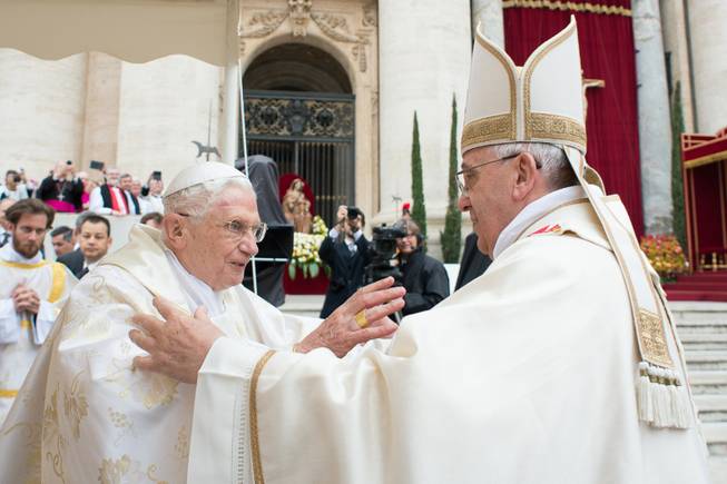 In this photo provided by the Vatican newspaper L'Osservatore Romano, Pope Francis, right, embraces his predecessor Pope Emeritus Benedict XVI, during a ceremony in St. Peter's Square at the Vatican, Sunday, April 27, 2014. 