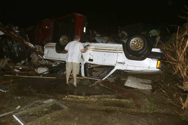 John Ward, an automobile and RV dealer, looks an tornado damage to one of his trucks in Mayflower, Ark., Sunday, April 27, 2014. 
