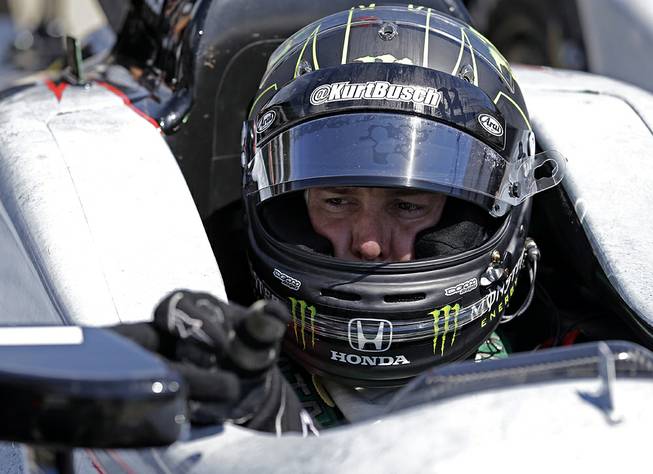 Race driver Kurt Busch adjusts the mirror of his car during a break in practice at Indianapolis Motor Speedway during the Rookie Orientation Program in Indianapolis, Tuesday, April 29, 2014. 