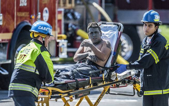 An injured worker is moved toward a waiting ambulance after an explosion was reported at a business in La Habra, Calif., Tuesday, April 29, 2014.
