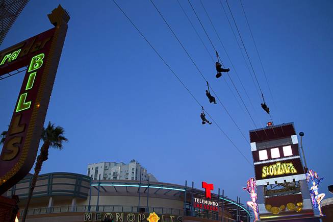 "Flyers" try out the new 850-feet-long SlotZilla Zipline at the Fremont Street Experience in downtown Las Vegas, Wednesday, April 30, 2014. A higher and longer 1700-feet-long Zoomline, which will propel flyers in a horizontal "superman" position at speeds up to 35 mph, is expected to open in June. The zip-line, part of the $12 million SlotZilla project, opened Sunday.
