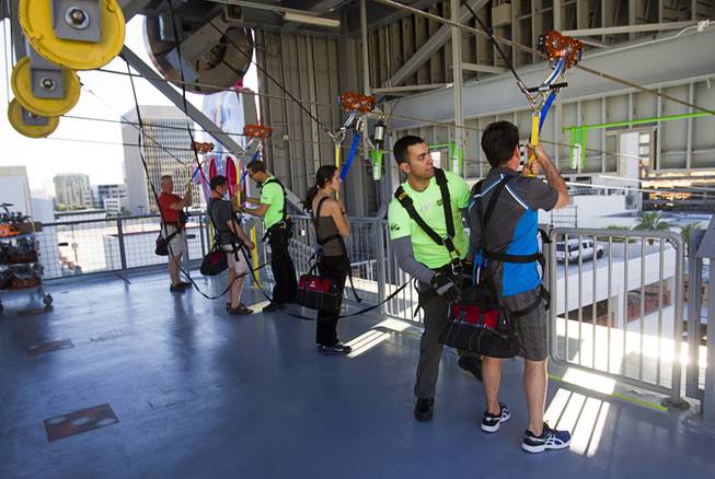 Launch operators get "flyers" ready to try the 850-feet-long SlotZilla Zipline at the Fremont Street Experience in downtown Las Vegas, Wednesday, April 30, 2014. A higher and longer 1700-feet-long Zoomline, which will propel flyers in a horizontal "superman" position at speeds up to 35 mph, is expected to open in June. The zip-line, part of the $12 million SlotZilla project, opened April 27, 2014.