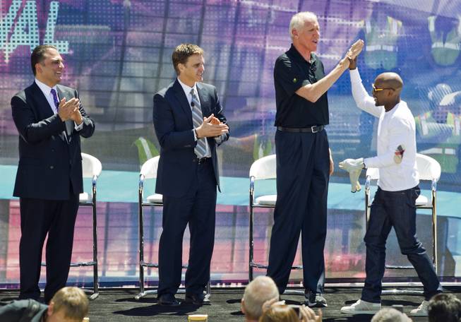 Undefeated boxing champion Floyd Mayweather Jr. greets former NBA star Bill Walton and others onstage at the AEG and MGM Resorts International groundbreaking VIP/media event atop a bulldozer on Thursday, May 1, 2014, in Las Vegas.