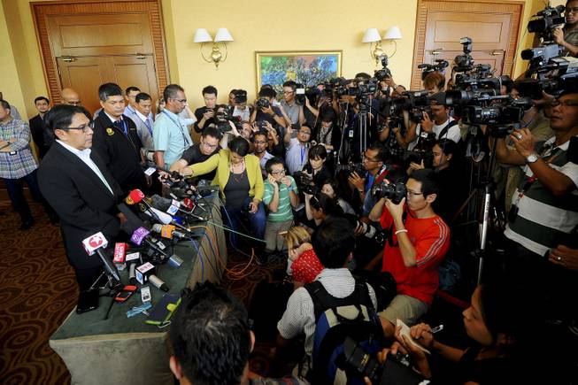 Malaysia's civil aviation chief Azharuddin Abdul Rahman, left, speaks during a press conference after a closed-door meeting with Chinese relatives of the passengers on the missing Malaysia Airlines Flight 370 at a hotel in Bangi, on the outskirts of Kuala Lumpur, Malaysia, Wednesday, April 2, 2014.