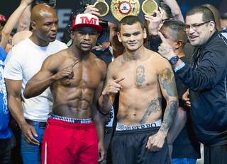 WBC welterweight champion Floyd Mayweather Jr., left,  and WBA champion Marcos Maidana of Argentina pose during an official weigh-in at the MGM Grand Garden Arena Friday, May 2, 2014. The two champions will meet in a WBC/WBA unification fight at the arena on Saturday.