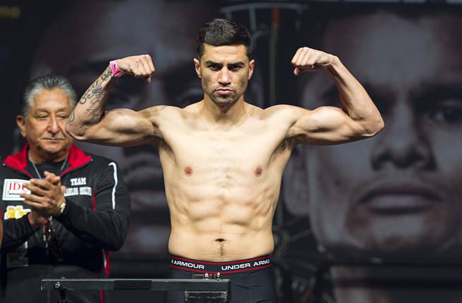 Carlos Molina poses on the scale during an official weigh-in at the MGM Grand Garden Arena Friday, May 2, 2014.  Molina faces Adrien Broner in a super lightweight fight at the arena on Saturday.