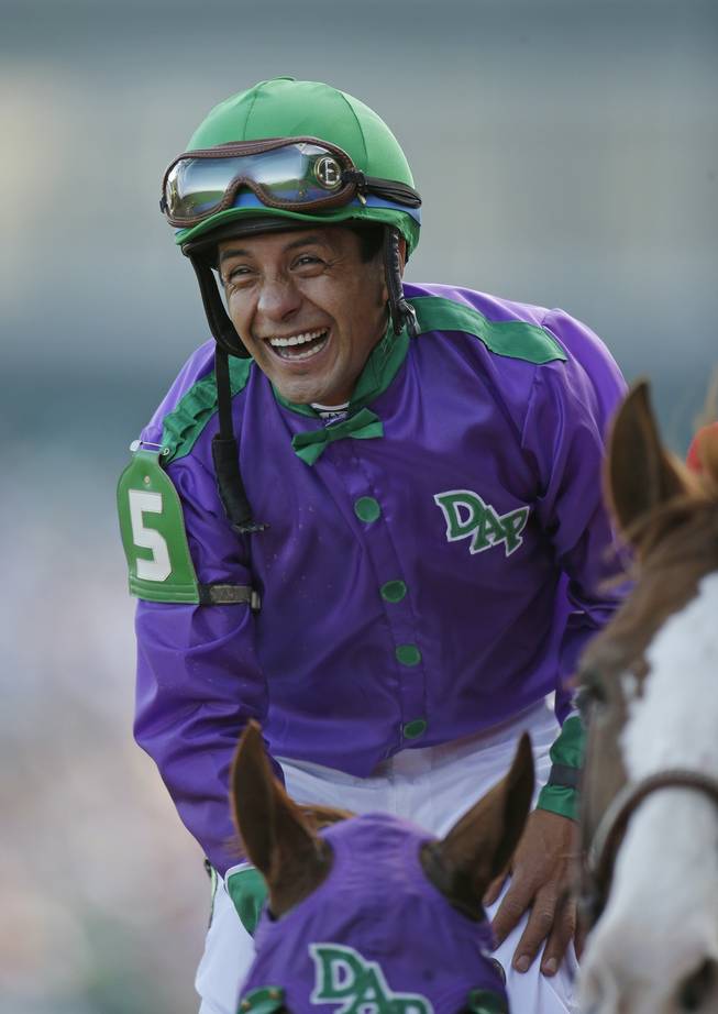 Victor Espinoza smiles after riding California Chrome to a victory during the 140th running of the Kentucky Derby horse race at Churchill Downs on Saturday, May 3, 2014, in Louisville, Ky.