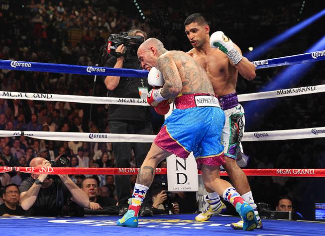 Amir Khan (R) of Britain connects with a punch that knocks down Luis Collazo during their welterweight fight at the MGM Grand Garden Arena Saturday, May 3, 2014.