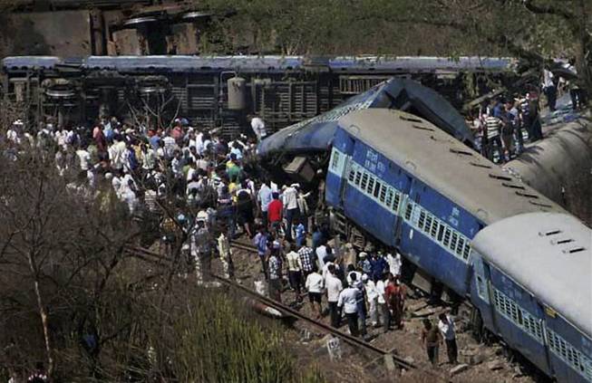 People gather around a passenger train that derailed near Roha station, 110 kilometers (70 miles) south of Mumbai, Maharashtra state, India, Sunday, May 4, 2014. The cause of the accident was not immediately known.