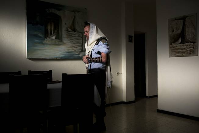 Jewish ultra-Orthodox military captain Moshe Prigan, performs his morning prayer at home in the ultra-Orthodox Jewish town of Bnei Brak, near Tel Aviv, Israel. Prigan doesn't just serve in the Israeli military, he also recruits other ultra-Orthodox Jewish men to enlist, something the cloistered community has traditionally avoided doing. The issue of military service is at the core of a cultural war over the place of ultra-Orthodox Jews in Israeli society today.