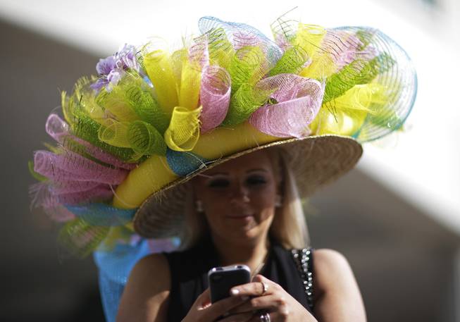 Ashley Cebak of Chicago looks at her phone before the 140th running of the Kentucky Derby horse race at Churchill Downs Saturday, May 3, 2014, in Louisville, Ky. 
