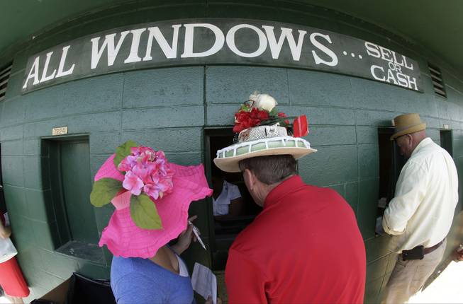 Fans make wagers before the 140th running of the Kentucky Derby horse race at Churchill Downs Saturday, May 3, 2014, in Louisville, Ky. 