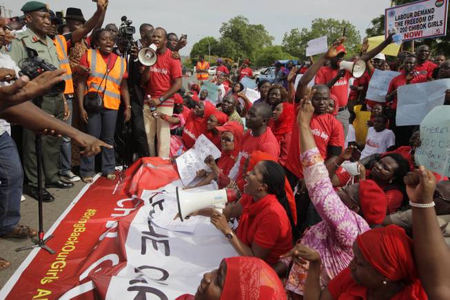 Brig. Gen. Chris Olukolade, Nigeria's top military spokesman, left, speaks to people at a demonstration calling on the government to rescue the kidnapped school girls of a government secondary school Chibok, outside the defense headquarters in Abuja, Nigeria, Tuesday May 6, 2014. 