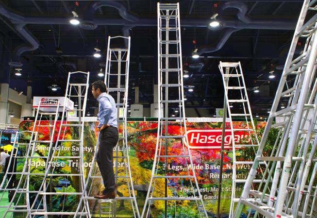 Kinya Osaka displays a series of Hasegawa ladders during the National Hardware Show 2014 in the Las Vegas Convention Center on Wednesday, May 7, 2014.   L.E. Baskow