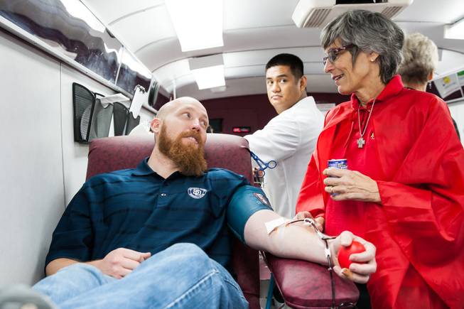 GriefShare facilitator Carol Von Eschen visits with Shane Price, 35, while donating blood in the United Blood Services' mobile van during the blood drive at New Song Church in Henderson Sunday, April 6, 2014.