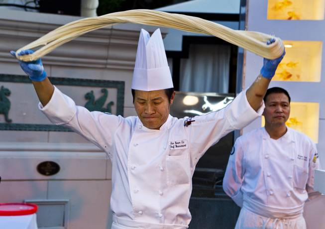 Chef Jin Yuan Li prepares noodles for the crowd at the Grand Tasting during the Uncork'd annual event from Caesars Garden of the Gods Pool on Friday, May 9, 2014.