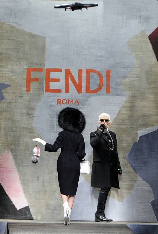 Fashion designer Karl Lagerfeld  is seen at the end of Fendi women's Fall-Winter 2014-15 collection, part of the Milan Fashion Week, unveiled in Milan, Italy, Thursday, Feb.20, 2014. At the top is a drone camera flying over the catwalk.