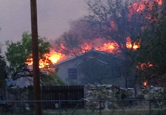 In this Sunday, May 11, 2014 photo provided by the Texas Department of Public Safety, a wildfire burns near Fritch, Texas. The wildfire has led to evacuations and road closures and has destroyed dozens of homes.