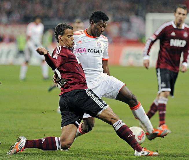 Nuremberg's Timothy Chandler of the U.S., left, and Bayern's David Alaba of Austria challenge for the ball during a soccer match in Nuremberg, Germany, Nov. 17, 2012. 