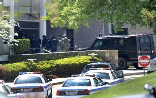 Police officers enter WMAR-TV, after a truck driven by a man rammed the Baltimore-area television station Tuesday, May 13, 2014 leaving a gaping hole in the front of the building, in Towson, Md.