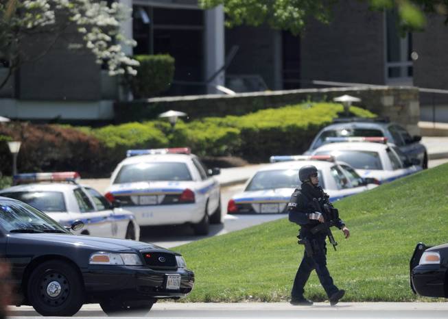 A police officer walks near WMAR-TV, after a truck driven by a man rammed the Baltimore-area television station Tuesday, May 13, 2014 leaving a gaping hole in the front of the building, in Towson, Md.
