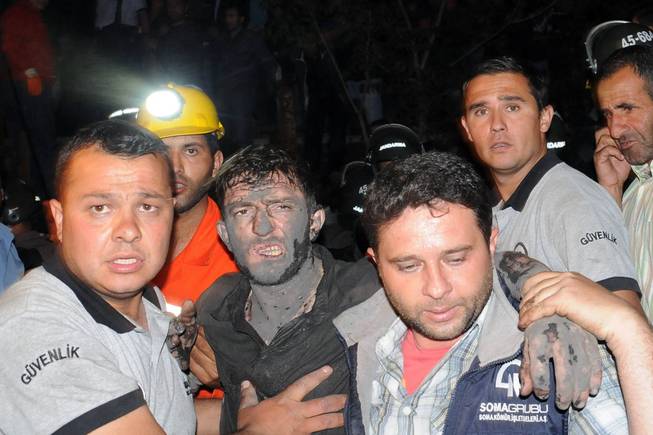 Medics help a rescued miner after an explosion and fire at a coal mine killed at least 17 miners and left up to 300 workers trapped underground, in Soma, in western Turkey, Tuesday, May 13, 2014, a Turkish official said.