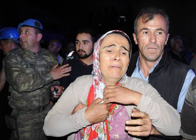 Family members gather near the mine after an explosion and fire at a coal mine killed at least 17 miners and left up to 300 workers trapped underground, in Soma, in western Turkey, Tuesday, May 13, 2014, a Turkish official said.