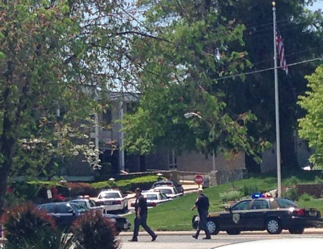 Police officers walk near WMAR-TV Tuesday, May 13, 2014, in Towson Md. Baltimore County police say a vehicle has rammed a television station and there may be an armed person inside the building.