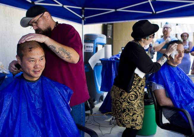 Zappos CEO Tony Hsieh joins other employees as they receive haircuts during the 10th Annual Zappos Bald and Blue charity event on Wednesday, May 15, 2014.