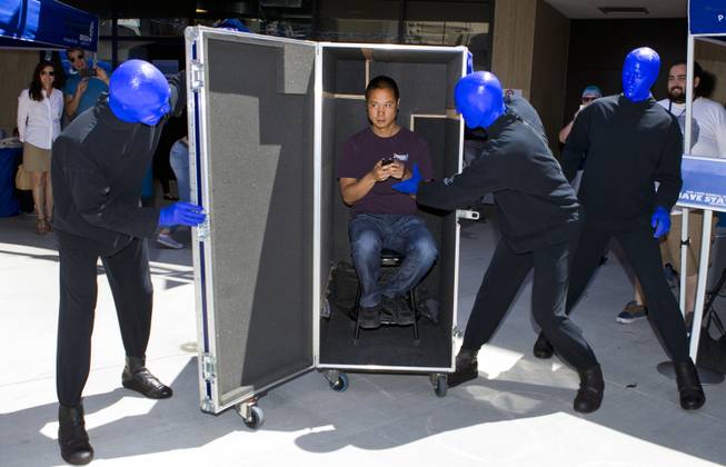 The Blue Man Group unveils Zappos CEO Tony Hsieh from within a rolling case during the 10th Annual Zappos Bald and Blue charity event on Wednesday, May 15, 2014.