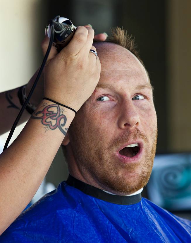 Luke Johnson with Zappos has his head shaved with many others during the 10th Annual Zappos Bald and Blue charity event on Wednesday, May 15, 2014.