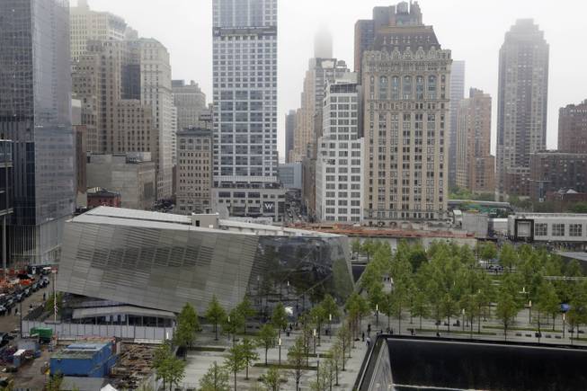 The pavilion entrance to the National September 11 Memorial Museum, center, is next to one of the memorial reflecting pools, lower right, Thursday, May 15, 2014 in New York.