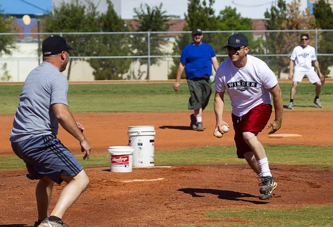 Sean McCrady, right, Las Vegas regional sales director for Winder Farms, reacts as Tim Hanko pretends to charge the mound during a casual Sunday baseball game at Red Ridge Park May 11, 2014.
