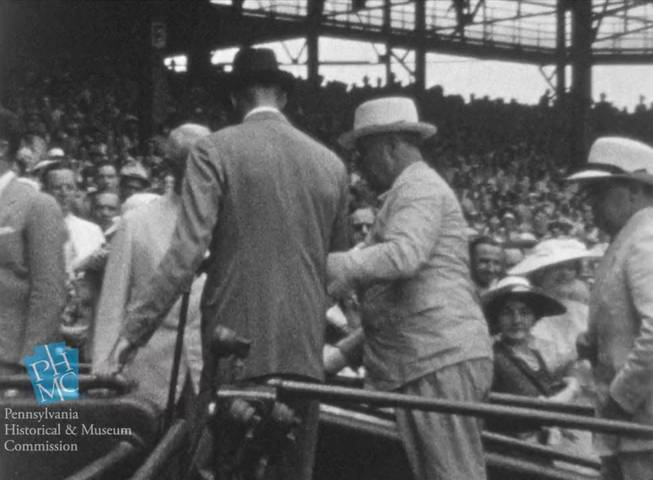 In this image taken from film shot by former Major League Baseball player Jimmie DeShong and acquired by the Pennsylvania Historical & Museum Commission, President Franklin D. Roosevelt, center right, walks to his seat with the aid of an assistant at the Major League Baseball All-Star game on July 7, 1937, at Griffith Stadium in Washington.