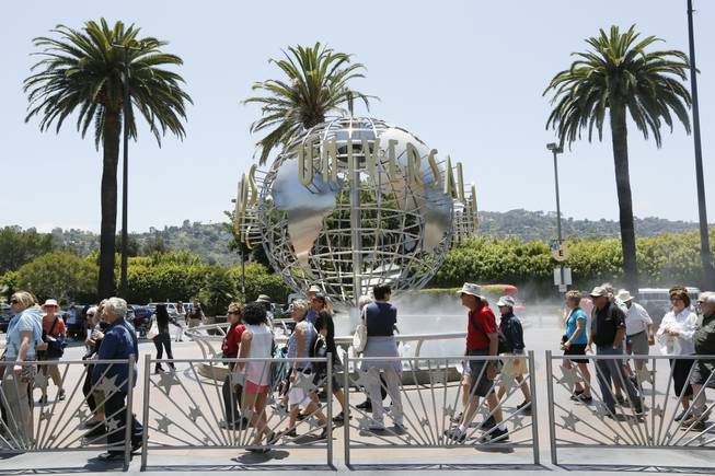 This photo taken Wednesday, June 5, 2013, show tourists lining up at the normal line at Universal Studios Hollywood in Los Angeles. 