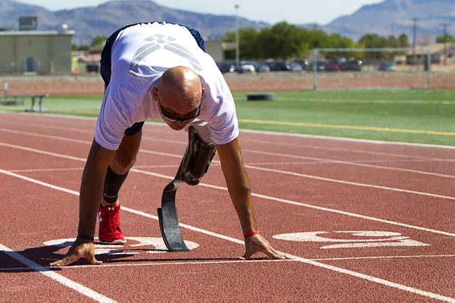 Mstr. Sgt. Christopher Aguilera is shown in the start position at the outdoor track at Nellis Air Force Base Wednesday, May 21, 2014. Aguilera was selected as one of 40 Air Force members to participate in the 2014 London Invictus Games for wounded veterans. Aguilera was injured when his helicopter was shot down in Afghanistan in 2010.